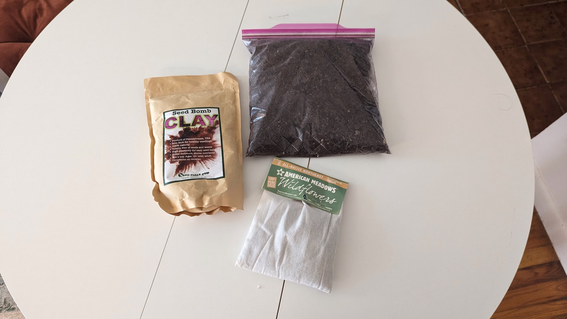 Compost, clay and wildflower seeds laid out on a table